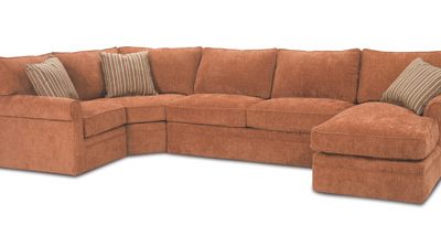 A sectional couch with a pillow on top of it.