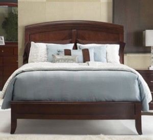 A bed with blue sheets and pillows on it