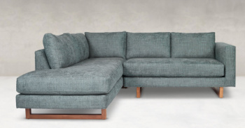 A couch with two pillows and wooden legs.